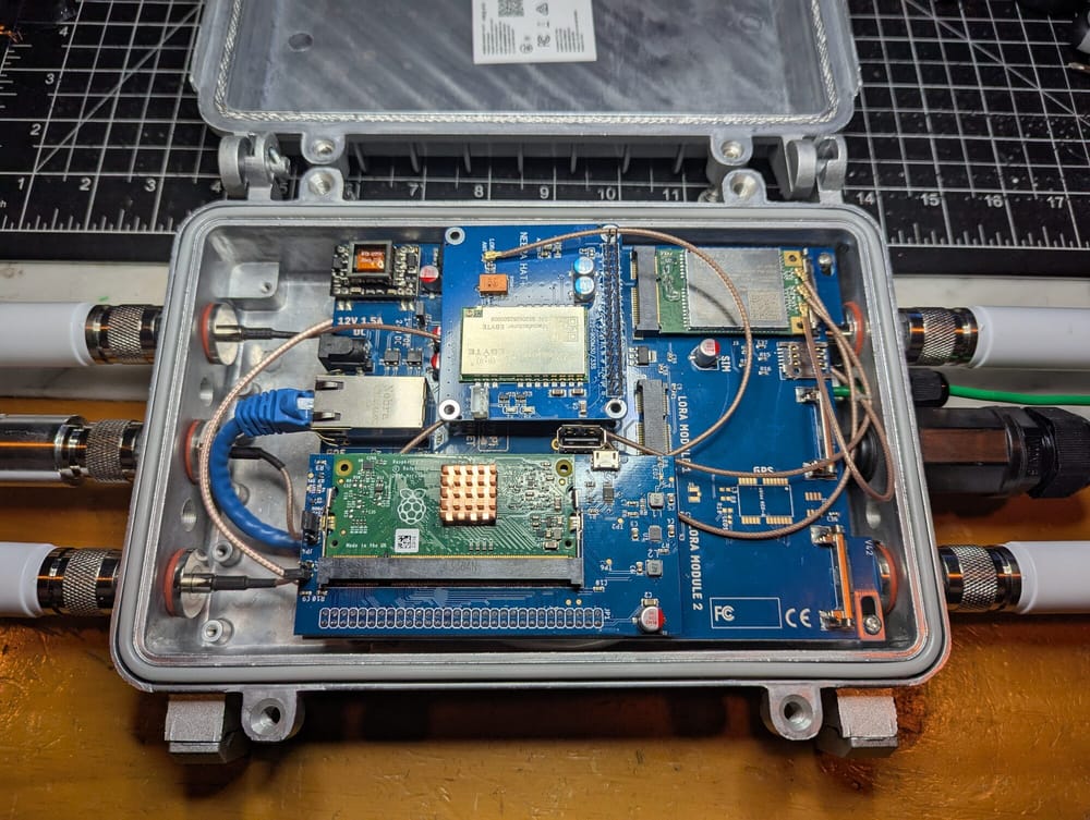 A Nebra outdoor enclosure opened up, with a LoRa hat, Raspberry Pi CM3 and LTE modem installed